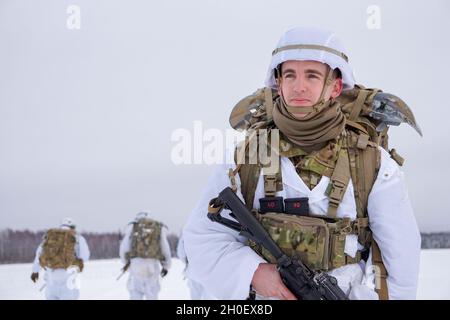 Ein Fallschirmjäger mit dem Kampfteam der 4. Infanterie-Brigade (Airborne), 25. Infanterie-Division, zieht nach einer Luftoperation im Rahmen von Arctic Warrior 21, 18. Februar, in der Malemute Drop Zone, Alaska, in das Versammlungsgebiet. Die Fallschirmjäger des 1. Bataillons, des 501. Fallschirmjäger-Infanterie-Regiments und des 6. Brigade-Ingenieur-Bataillons (Airborne) sprangen zuvor in verschneiten Himmel und beendeten dann Ruck-Märsche, um ihre Fähigkeit zu bestätigen, luftgestützte Operationen unter arktischen Bedingungen durchzuführen. Die Spartan Brigade ist das einzige Luftgefecht-Brigade-Kampfteam in den arktischen und pazifischen Theatern, pro Stockfoto