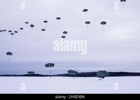 Fallschirmjäger mit dem Kampfteam der 4. Infanterie-Brigade (Airborne), 25. Infanterie-Division, führten im Rahmen von Arctic Warrior 21, 18. Februar, in der Malemute Drop Zone, Alaska, eine zweite Luftoperation durch. Die Fallschirmjäger des 1. Bataillons, des 501. Fallschirmjäger-Infanterie-Regiments und des 6. Brigade-Ingenieur-Bataillons (Airborne) sprangen zuvor in verschneiten Himmel und beendeten dann Ruck-Märsche, um ihre Fähigkeit zu bestätigen, luftgestützte Operationen unter arktischen Bedingungen durchzuführen. Die Spartan Brigade ist das einzige Luftgefechterteam der Infanteriebrigade im arktischen und pazifischen Raum, das das Kampfflugzeugkommando zur Verfügung stellt Stockfoto