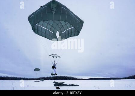 Fallschirmjäger mit dem Kampfteam der 4. Infanterie-Brigade (Airborne), 25. Infanterie-Division, führten im Rahmen von Arctic Warrior 21, 18. Februar, in der Malemute Drop Zone, Alaska, eine zweite Luftoperation durch. Die Fallschirmjäger des 1. Bataillons, des 501. Fallschirmjäger-Infanterie-Regiments und des 6. Brigade-Ingenieur-Bataillons (Airborne) sprangen zuvor in verschneiten Himmel und beendeten dann Ruck-Märsche, um ihre Fähigkeit zu bestätigen, luftgestützte Operationen unter arktischen Bedingungen durchzuführen. Die Spartan Brigade ist das einzige Luftgefechterteam der Infanteriebrigade im arktischen und pazifischen Raum, das das Kampfflugzeugkommando zur Verfügung stellt Stockfoto