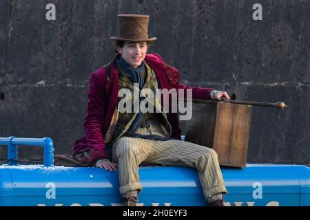 Lyme Regis, Dorset, Großbritannien. Oktober 2021. Szenen für den neuen Wonka-Film mit Timothée Chalamet, der heute Nachmittag im Hafen von Cobb bei Lyme Regis in Dorset gedreht wird. Timothée Chalamet, der den jungen Willy Wonka spielt, wird auf einem Van-Dach reiten sehen. Bildnachweis: Graham Hunt/Alamy Live News Stockfoto