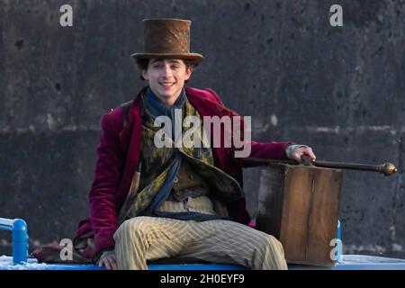 Lyme Regis, Dorset, Großbritannien. Oktober 2021. Szenen für den neuen Wonka-Film mit Timothée Chalamet, der heute Nachmittag im Hafen von Cobb bei Lyme Regis in Dorset gedreht wird. Timothée Chalamet, der den jungen Willy Wonka spielt, wird auf einem Van-Dach reiten sehen. Bildnachweis: Graham Hunt/Alamy Live News Stockfoto