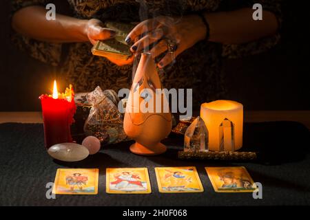 Detail der Hände einer Frau mit Tarot-Karten. Konzept einer zukünftigen Lesesitzung mit Tarot-Karten. Stockfoto