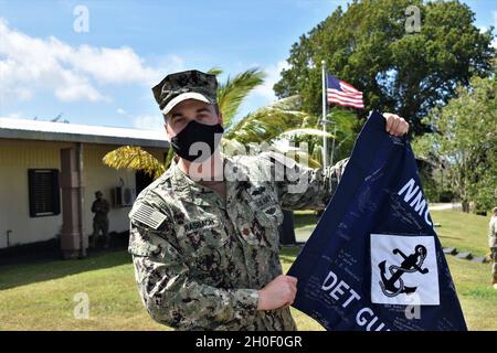 210218-N-SK929-1047 SANTA RITA, Guam (Feb 18, 2021) Lt. Cmdr. Austin Rasbach, Naval Mobile Construction Bataillon (NMCB) 133 Det. Guam, der zuständige Offizier, erhält nach einer Zeremonie zur Entlastung/Übertragung von Befugnissen (RIP/TOA) eine Anleitung von seinem Verdienst. Während der Zeremonie, NMCB 133 Det. Guam wurde durch NMCB 11 det entlastet. Guam. Stockfoto