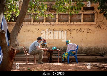 US Army Staff Sgt. Aidan McNulty, dem Civil Affairs Team (CAT) 142, Delta Co. 91. Civil Affairs Bataillon, zugewiesen, leistet medizinische Hilfe für einen Bürger von Burkina Faso in Bobo-Dioulasso, Burkina Faso, 19. Februar 2021. Angehörige des US-Militärs stellten in Bobo-Dioulasso medizinische Geräte und Schulungen für die Militärärzte von Burkinabé bereit. Die Ausbildung unterstützte die medizinischen Untersuchungen und Behandlungen von mehr als 400 Menschen mit der US-Militärhilfe, die sich auf den Aufbau der Kapazitäten der Sicherheitskräfte Burkina Fasos konzentrierte. Stockfoto