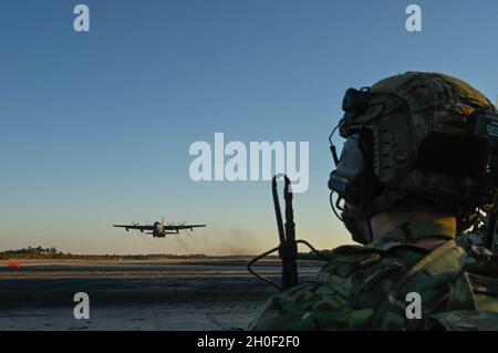 Ein Spezialtaktikoperator der US-Luftwaffe kommuniziert mit der Luftbesatzung eines MC-130H Combat Talon II, der dem 15. Spezialeinsatzgeschwader auf dem Hurlburt Field zugewiesen wurde, während sie während des Emerald Warrior 21.1 in Eglin Range, Florida, am 19. Februar 2021 von einem Flugplatz abheben. Emerald Warrior ist die größte gemeinsame Spezialoperationsübung, bei der die US-Spezialeinsatzkommandos geschult werden, um auf verschiedene Bedrohungen im gesamten Spektrum des Konflikts zu reagieren. Stockfoto