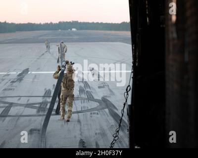 US Air Force Airman 1st Class Jose Moreno (links), ein Vorwärtsbereich-Tankpunktmitglied, das dem 1st Special Operations Logistics Readiness Squadron, Airman 1st Class Mathew Lenz (Mitte), einem Spezialeinsatzflieger mit dem 15th Special Operations Squadron und Staff Sgt zugewiesen wurde. Dalton Haywood (rechts), ein FARP-Mitglied, das dem 1. SOLRS zugewiesen wurde, bereitet sich auf die Durchführung einer FARP-Operation mit einem US-Navy MH-60 Sea Hawk Hubschrauber vor, der während des Emerald Warrior 21.1 im Hurlburt Field, Florida, am 20. Februar 2021 dem Hubschrauber Sea Combat Squadron (HSC) 9 zugewiesen wurde. Emerald Warrior ist das größte gemeinsame Spezial OPE Stockfoto
