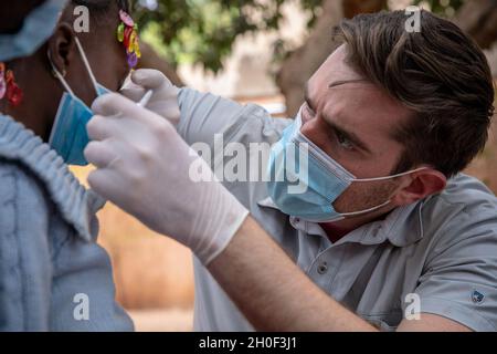 US Army Staff Sgt. Aidan McNulty, dem Civil Affairs Team (CAT) 142, Delta Co. 91. Civil Affairs Bataillon, zugewiesen, leistet medizinische Hilfe für einen Bürger von Burkina Faso in Bobo Dioulasso, Burkina Faso, 20. Februar 2021. Angehörige des US-Militärs stellten in Bobo-Dioulasso medizinische Geräte und Schulungen für die Militärärzte von Burkinabé bereit. Die Ausbildung unterstützte die medizinischen Untersuchungen und Behandlungen von mehr als 400 Menschen mit der US-Militärhilfe, die sich auf den Aufbau der Kapazitäten der Sicherheitskräfte Burkina Fasos konzentrierte. Stockfoto