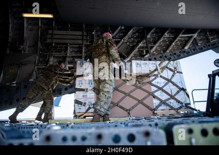 U.S. Air Force Airmen mit dem 502. Logistics Readiness Squadron unterstützen die Koordination und das Entladen von mehr als 57,000 Flaschen Wasser auf einer C-17 vom 16th Airlift Squadron, Joint Base Charleston, S.C., 21. Februar 2021, Am Joint Base San Antonio-Kelly Field, Texas. Der 502LRS unterstützte die Koordination und das Entladen von mehr als 150,000 Pfund abgefülltem Wasser, das über Flugzeuge auf dem Kelly Field in die Stadt San Antonio gebracht wurde. Stockfoto