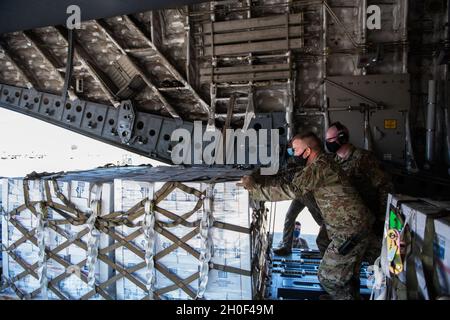 Flieger mit dem 502. Logistics Readiness Squadron unterstützen die Koordination und Entladung von mehr als 57,000 Flaschen Wasser auf einer C-17 von der 16. Airlift Squadron, Joint Base Charleston, S.C., 21. Februar 2021, Am Joint Base San Antonio-Kelly Field, Texas. Der 502LRS unterstützte die Koordination und das Entladen von mehr als 150,000 Pfund abgefülltem Wasser, das über Flugzeuge auf dem Kelly Field in die Stadt San Antonio gebracht wurde. Stockfoto