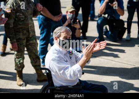 Der Gouverneur von Texas, Greg Abbott, beobachtet, wie Airmen mit dem 502. Logistics Readiness Squadron bei der Koordination und dem Entladen von etwa 80,000 Wasserflaschen hilft, die über Flugzeuge auf dem Kelly Field in die Stadt San Antonio gebracht werden, nachdem der Wintersturm Uri, 21. Februar 2021, Am Joint Base San Antonio-Kelly Field, Texas. Stockfoto