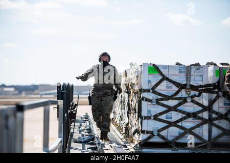 U.S. Air Force Airmen mit dem 502. Logistics Readiness Squadron unterstützen die Koordination und das Entladen von mehr als 57,000 Flaschen Wasser auf einer C-17 vom 16th Airlift Squadron, Joint Base Charleston, S.C., 21. Februar 2021, Am Joint Base San Antonio-Kelly Field, Texas. Der 502LRS unterstützte die Koordination und das Entladen von mehr als 150,000 Pfund abgefülltem Wasser, das über Flugzeuge auf dem Kelly Field in die Stadt San Antonio gebracht wurde. Stockfoto