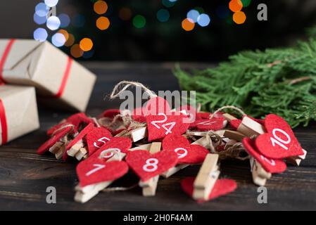 Adventskalender vorbereitet für den Feiertag, DIY Weihnachten, Geschenke für Kinder auf dunklem Holzhintergrund, Nahaufnahme. Stockfoto