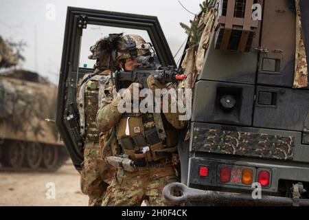 Italienische Soldaten der Bravo Company, 11. Bersaglieri Bataillon, sorgen nach einem simulierten Hinterhalt im Joint Multinal Readiness Center in Hohenfels Training Area, Deutschland, am 21. Februar 2021 für Sicherheit. Combined Resolve XV unterstreicht nicht nur die Beziehung zwischen dem Kampfteam der 1. Panzerbrigade der 1. Kalvariendivision und unseren Partnern und Verbündeten, sondern auch unser Engagement für dieselben Partner und Verbündeten. Stockfoto