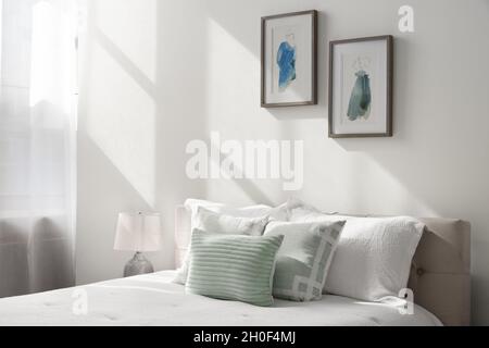 Gemütliches Detail, das auf die Wand und das Bett fällt. Stockfoto