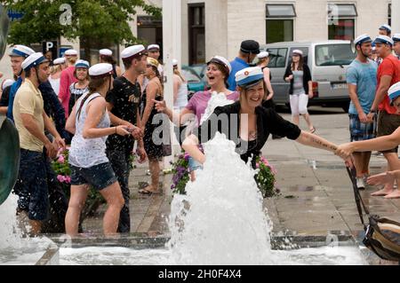 Gymnasiasten, die am 25. Juni 2009 in Aarhus, Dänemark, in der Nähe eines Brunnens ihren Abschluss feiern Stockfoto