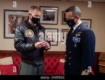 US Navy Capt. Cassidy Norman, Kommandant des Flugzeugträgers USS John C. Stennis (CVN 74), links, präsentiert dem Marinechelakttaché, Capt. Gianfranco Vizzini, eine Challenge-Münze im Rahmen eines Geschenkwechsels in der Kabine des Kapitäns an Bord der John C. Stennis in Norfolk, Virginia, Februar 22, 2021. John C. Stennis arbeitet mit Newport News Shipbuilding zusammen, um die Überholung des Tankkomplexes planmäßig mit einer geschulten, widerstandsfähigen und geschlossenen Crew abzuschließen. Stockfoto