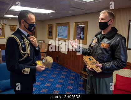 Der italienische Marineinfantaché Gianfranco Vizzini, links, spricht mit dem US-Marineinfantachat Cassidy Norman, dem Kommandanten des Flugzeugträgers USS John C. Stennis (CVN 74), im Rahmen eines Geschenkwechsels in der Hafenkabine des Kapitäns an Bord der John C. Stennis in Norfolk, Virginia, 22. Februar 2021. John C. Stennis arbeitet mit Newport News Shipbuilding zusammen, um die Überholung des Tankkomplexes planmäßig mit einer geschulten, widerstandsfähigen und geschlossenen Crew abzuschließen. Stockfoto