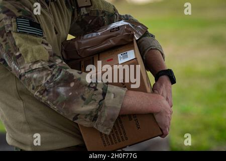 Capt. Jesse Reynolds, 41. Rettungstaffel-Pilot, hält eine Kiste mit Mahlzeiten, Ready to Eat während Mosaic Tiger 21-1, 22. Februar 2021, auf der MacDill Air Force Base, Florida. Mosaic Tiger 21-1 war die erste agile Kampfübung des 23d-Flügels, bei der sie als Führungsflügel für etwa 800 Luftwaffe von sieben Flügeln in vier Hauptkommandos fungierten. Das 23d Wing Integration and Training Office testete den Einsatz von multifähigen Flugzeugen, einem neuen Tankgerät, einem neuen Verfahren für das Anheben von Luftwaffen und einem Air-Personal, dessen Aufgabe es war, einem Forwa Kommando und Kontrolle zu geben Stockfoto