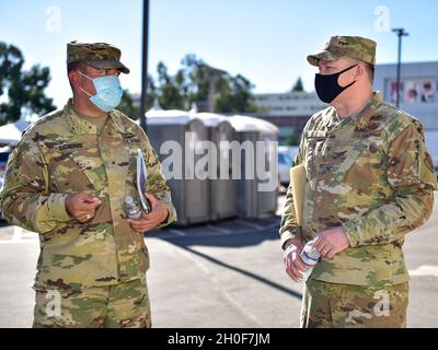 Der Oberst der US-Luftwaffe, Robert Sage, rechts, Kommandeur des 195. Flügels der California National Guard, spricht mit der Majors der US-Armee. Leroy Cisneros, Kommandeur der Joint Task Force Mustang, California National Guard, spricht vor dem Drive-Thru-Gelände des COVID-19 Community Impfzentrums im Cal State Los Angeles, Februar 23, 2021. Über 30 Luftwaffe des Flügels wurden als Teil der gemeinsamen Truppe aktiviert, um die Impfbemühungen administrativ zu unterstützen. Stockfoto