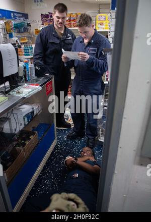 210223-N-RG171-0021 MITTELMEER (FEB 23, 2021) Schaden Controlman 2. Klasse Matthew Smith, links, und Machinist's Mate 3. Klasse Nicholy Smith, rechts, bereitet sich darauf vor, dem Hospital Corpsman 3. Klasse Priscilla Jean-Francois während einer medizinischen Trainingsentwicklung an Bord des Arleigh Burke-Klasse Lenkflugkörper-Zerstörers USS Donald Cook (DDG 75), 23. Februar 2021, erste Hilfe zu leisten. Donald Cook, der im spanischen Rota stationiert ist, ist auf Patrouille im Einsatzgebiet der Sechsten Flotte der USA, um regionale Verbündete und Partner sowie die nationale Sicherheit der USA in Europa und Afrika zu unterstützen. Stockfoto