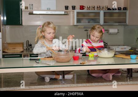 Zwei Kinder Vorbereitung süße Muffins in der Küche Stockfoto