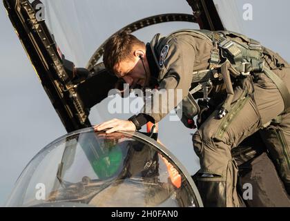 Ein dem 492. Jagdgeschwader zugewiesenes Mitglied der Luftcrew tritt vor dem Start bei der Royal Air Force Lakenheath, England, in das Cockpit eines F-15E Strike Eagle ein, um einen multinationalen Überflug am 24. Februar 2021 zum estnischen Unabhängigkeitstag zu unterstützen. Die Teilnahme der Vereinigten Staaten am estnischen Unabhängigkeitstag zeigt das entschlossene Engagement der NATO-Verbündeten und -Partner für die Sicherheit und territoriale Integrität. Stockfoto