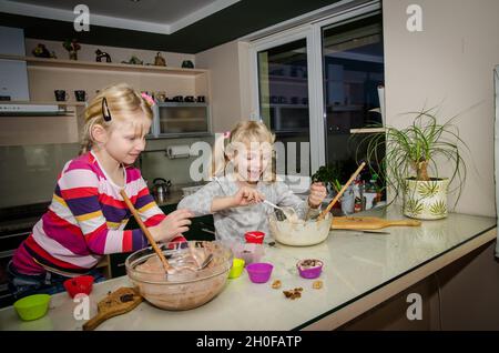 Zwei Kinder Vorbereitung süße Muffins in der Küche Stockfoto
