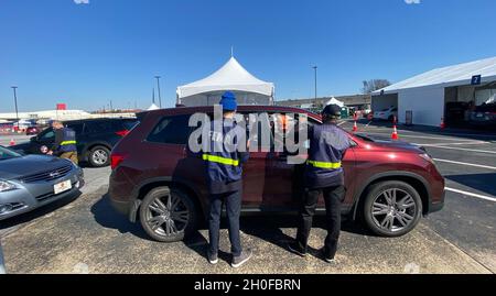 Hapeville, GA (24. Februar 2021) – Lokale, staatliche und bundesstaatliche Partner arbeiten an einer Impfstelle zusammen, die in Fulton County auf dem Delta Museum Parking Lot eingerichtet wurde. Mitarbeiter der FEMA registrieren Einwohner, die zur Impfung vor Ort gekommen sind. Stockfoto