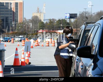 Hapeville, GA (24. Februar 2021) - Lokale, staatliche und bundesstaatliche Partner arbeiten an einer Impfstelle zusammen, die auf dem Delta Museum Parking Lot in Fulton County eingerichtet wurde. Die Mitarbeiter der FEMA arbeiten mit Krankenschwestern zusammen, die Patienteninformationen abrufen. Stockfoto