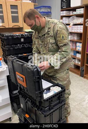 Sgt. Michael Fischer, ein Kampfmediziner, der dem 92. Truppenkommando der Nebraska-Armee zugewiesen wurde, inventarisiert und verpackt medizinische Hilfsgüter im Büro des Gesundheitsministeriums des West Central District in North Platte, Nebraska, 24. Februar 2021, In Vorbereitung auf eine Massenimpfklinik, die für den folgenden Tag für die Arbeiter von Bailey Yard, dem größten Eisenbahnklassifizierungshof der Welt, geplant ist Stockfoto