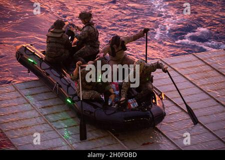 US-Marineinfanteristen mit der 31. Marine Expeditionary Unit (MEU) und Matrosen der Marine bereiten sich darauf vor, während einer Onload-Übung an Bord des Landungsschiffes USS Ashland (LSD 48) in der philippinischen See, 24. Februar 2021, ein Kampfflugzeugnis zu starten. Die 31. MEU ist an Bord der Schiffe der Amphibiengeschwader 11 im Einsatzgebiet der 7. Flotte tätig, um die Interoperabilität mit Verbündeten und Partnern zu verbessern und als einsatzbereite Einsatztruppe zur Verteidigung von Frieden und Stabilität in der Indopazifik-Region zu dienen. Stockfoto