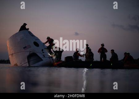 Pararescue Jumper und Combat Rettungsbeamte der 48th Rescue Squadron üben während des Qualifikationskurses der Rettungskräfte in der Cape Canaveral Air Force Station am 24. Februar 2021 die Rückgewinnung von Astronauten aus einem Weltraumkapsel-Modell. Der Qualifizierungskurs der Rettungskräfte wird vom Human Space Flight Support Office des Verteidigungsministeriums durchgeführt und bietet vierteljährliche Schulungen für Rettungskräfte des Verteidigungsministeriums, Partnerorganisationen und andere eCUE-Organisationen mit praktischen Anweisungen zur Astronautenrettung. Diese Schulung ermöglicht eine Vielzahl von Mitarbeitern aus verschiedenen Orga-Organisationen Stockfoto