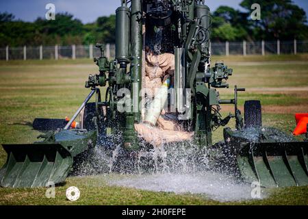 Aus dem Lauf eines M777-Howitzers wird ein 155-mm-Dummy-Projektil aufgrund hydraulischer Druckextraktionstechniken extrahiert, die von der Marine Corps Base Camp Butler Explosive Ordnance Disposal (EOD) auf Camp Hansen, Okinawa, Japan, 25. Februar 2021 durchgeführt wurden. EOD-Techniker und Artillerie-Marines führten normale M777-Howitzer-Schussverfahren durch, jedoch wurden Dummy-Runden absichtlich im 16.7-Fuß-Lauf des Waffensystems untergebracht, damit jede Einheit ihre Extraktionstechniken demonstrieren konnte. Nach der Vorbereitung demonstrierte jede Einheit ihre eigene Extraktionsmethode. Stockfoto