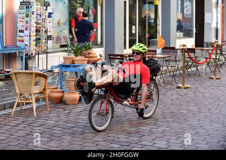 Mann auf einem Liegeergometer auf einer gepflasterten Straße in Freiburg Stockfoto