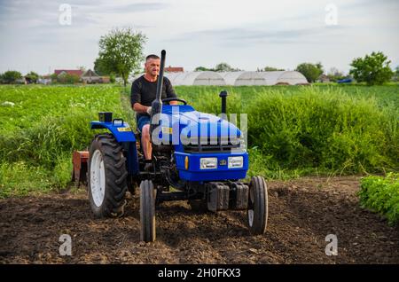 Cherson Oblast, Ukraine - 29. Mai 2021: Landwirt auf einem Traktor arbeitet auf dem Feld. Saisonarbeiter. Rekrutierung von Arbeitnehmern mit Fähigkeiten in der Landwirtschaft zu fahren Stockfoto