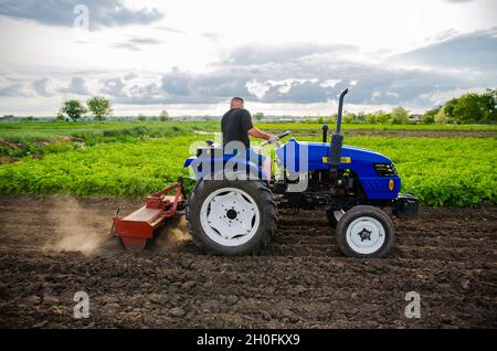 Cherson Oblast, Ukraine - 29. Mai 2021: Landwirt auf einem Traktor reinigt das Feld nach der Ernte. Betrieb eines kleinen Agrarunternehmens. Arbeit auf dem Bauernhof. Landwirtschaft. Loosenin Stockfoto