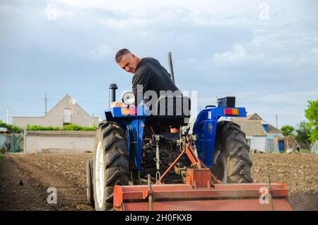 Cherson Oblast, Ukraine - 29. Mai 2021: Ein Landwirt auf einem Traktor reinigt das Feld nach der Ernte. Vorbereitung des Bodens für die zukünftige Pflanzung neuer Pflanzen. Millin Stockfoto