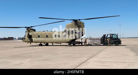 Mitglieder des 136. Logistics Readiness Squadron, Texas Air National Guard, laden Wasserpaletten auf einen CH-47 Chinook am 23. Februar 2021 auf dem Naval Air Station Joint Reserve Base, Fort Worth, Texas. Die Luftwaffe der 821. Notfallgruppe hat sich auf Ersuchen der Zivilbehörden und zur Unterstützung der Federal Emergency Management Agency und des U.S. Northern Command mit ihren Partnern der gesamten Streitkräfte zusammengebracht. Stockfoto