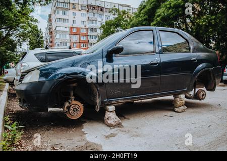 Ein defekter Pkw ohne Räder steht auf Ziegelsteinen. Stockfoto