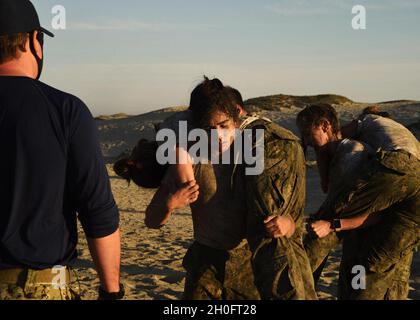 210226-N-BZ392-1159 - CORONADO, Kalifornien – Hochleistungssportler nehmen an Buddy Carry-Übungen während der „Insert Challenge“ von Naval Special Warfare (NSW) im Naval Special Warfare Center (NSWCEN) Teil, Februar 26. Die NSW Insert Challenge bot einen Einblick in die Fähigkeiten und kognitiven, Charakter- und Führungseigenschaften, die die Navy bei den unerschrockenen Männern und Frauen benötigt, die den SEAL- und SWCC-Teams beitreten wollen. NSWCEN bietet eine erste Beurteilung und Auswahl und anschließende Weiterbildung für die Segler, die die SEAL- und Special Boat-Teams der Marine bilden. Stockfoto