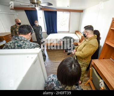 U.S. und Japanese Airmen stehen in einem Schlafsaal auf dem Campus der unbegleiteten Unterkünfte des 35. Kampfflügels auf dem Misawa Air Base, Japan, 26. Februar 2021. Während sie gerade dabei sind, ihren eigenen Campus zu verbessern, nahmen die Leiter der Japan Air Self-Defence Force vom 3rd Air Wing an der Tour Teil, um einen Einblick zu erhalten, wie die 35. FW ihren Campus verwaltet und betreibt. Während der Tour konnten sie Fragen zu den Möbel- und Gerätekosten stellen, die Bewohner von Zimmern, geteilten Wohnräumen und sogar den Schimmelschutz bestimmen. Stockfoto