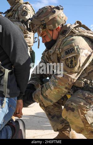 Ein US-Soldat, der der 64. Militärkompanie, dem 91. Brigade-Ingenieur-Bataillon, der 1. Kavalleriedivision, zugewiesen wurde, verhaftete am 27. Februar 2021 einen simulierten Verdächtigen während des Combined Resolve XV im Hohenfels Trainingsgebiet, Hohenfels, Deutschland. Combined Resolve XV ist eine vom Hauptquartier der Armee geleitete multinationale Übung, die zum Aufbau des Kampfteams der 1. Panzerbrigade, der Bereitschaft der 1. Kavallerie-Division und zur Verbesserung der Interoperabilität mit verbündeten Kräften entwickelt wurde, um gegen jeden Gegner zu kämpfen und zu gewinnen. Stockfoto