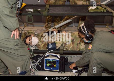 US Air Force Reserve Bürger-Flieger vom 514. Aeromedical Evacuation Squadron überprüfen die Vitalwerte und betreuen einen simulierten Patienten während einer Trainingsmission nach Isla Verde, Puerto Rico, mit dem Air Force Reserve Command, dem Air Mobility Command und dem 916. Lufttankungsflügel am 26. Februar 2021. Mitglieder der 514. UEs wurden an vielen verschiedenen Szenarien evaluiert, die entwickelt wurden, um den medizinischen Kampfdienst in der realen Welt an Bord der KC-46 Pegasus zu replizieren. Die Instruktoren waren vom Air Force Reserve Command und dem Air Mobility Command. Stockfoto