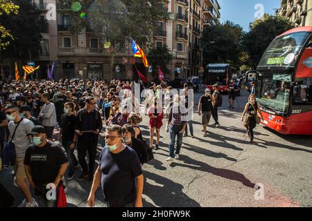 Barcelona, Katalonien, Spanien. Oktober 2021. Vor den Bussen werden Demonstranten gesehen, die die Straße durchschneiden.rund 400 Menschen aus antifaschistischen Gruppen haben eine Demonstration gegen die Ereignisse des 12. Oktober, dem Hispanic Day in Barcelona, aufgerufen. Die Demonstranten sind in die Richtung einiger dieser Handlungen gegangen, aber die Polizei hat sie bei allen Gelegenheiten verhindert. (Bild: © Thiago Prudencio/DAX via ZUMA Press Wire) Stockfoto