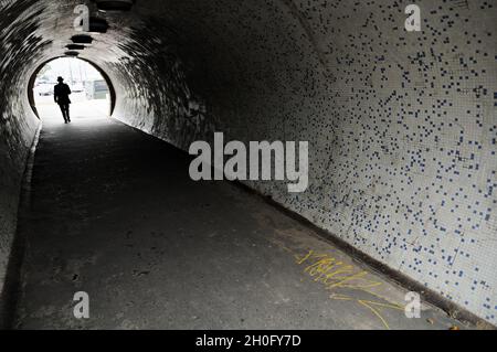 Silhouette eines Mannes in einem Tunnel unter der Kettenbrücke von Szechenyi in Budapest, Ungarn Stockfoto