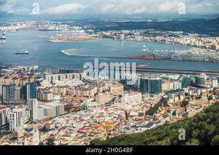 Erhöhter Blick auf einen Teil der Stadt Gibraltar, mit Blick auf die Start- und Landebahn des Flughafens und die Alcaidesa Marina zur CEPSA-Raffinerie Gibraltar-San Roque. Stockfoto