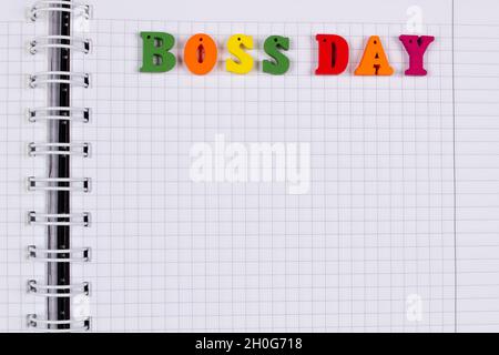 National Happy Boss Day. Bunte Buchstaben in einem karierten Übungsbuch auf dem Tisch. Bosses Day Office Grußkarte mit Kopierplatz für te Stockfoto