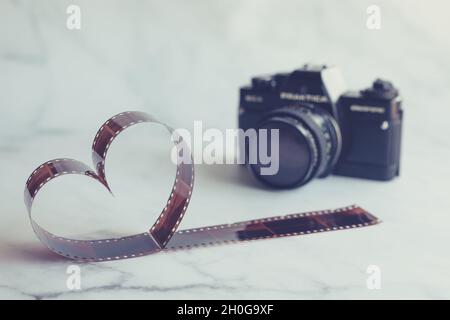 Filmnegativ in Form eines Herzens mit Vintage-Filmkamera Stockfoto