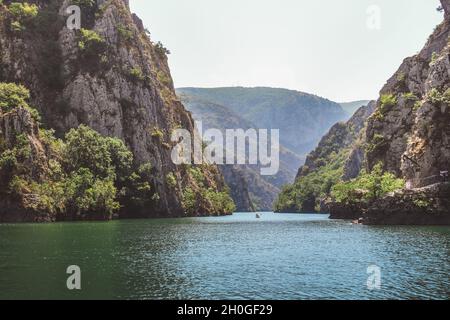 Blick auf den See in der Matka-Schlucht in der Nähe von Skopje, Republik Nordmakedonien. Kajak auf dem See Stockfoto