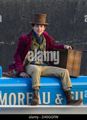 Lyme Regis, Dorset, Großbritannien. Oktober 2021. Szenen für den neuen Wonka-Film mit Timothée Chalamet, der heute Nachmittag im Hafen von Cobb bei Lyme Regis in Dorset gedreht wird. Timothée Chalamet, der den jungen Willy Wonka spielt, wird auf einem Van-Dach reiten sehen. Bildnachweis: Graham Hunt/Alamy Live News Stockfoto